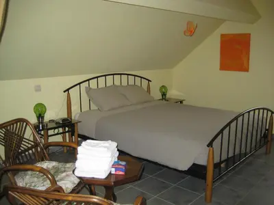 a bedroom with a large bed and two chairs at B&B Het Uilennest in Bocholt