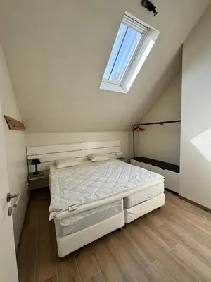 a bedroom with a bed and a skylight at De Oude Molen in As