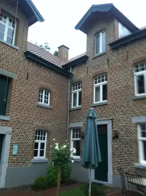 an umbrella in front of a brick building at De Oude Molen in As