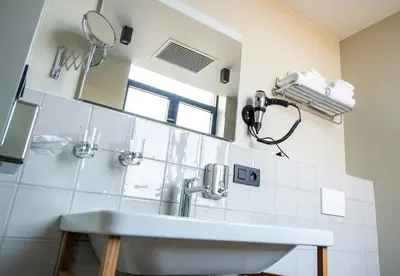 a bathroom with a sink and a mirror at Café Coureur Borgloon in Borgloon