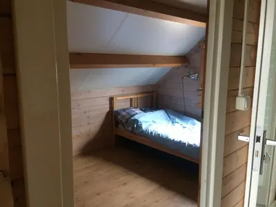 a bunk bed in a room with wood paneling at Thuiskomen, genieten aan het water in Maaseik
