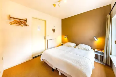 a bedroom with a large white bed in a room at De Appelgaard in Sint-Martens-Voeren