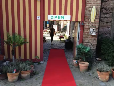 a red carpeted walkway leading to an open sign at B&B De Henehoeve in Heks