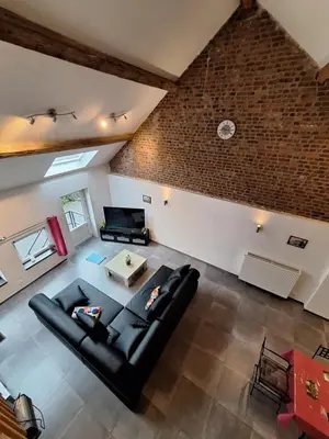 an overhead view of a living room with a black leather couch at Gîte Cour Delhez in Olne