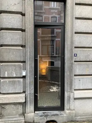 a window of a building with a reflection of a street at Gats Place in Liège