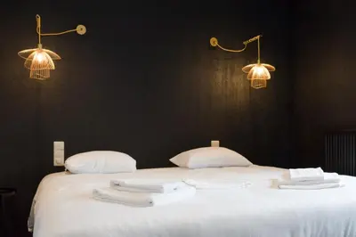 a bedroom with a bed with white towels on it at Hôtel Mosa in Hermalle-sous-Argenteau