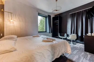 a bedroom with a large bed with two towels on it at Hôtel Mosa in Hermalle-sous-Argenteau