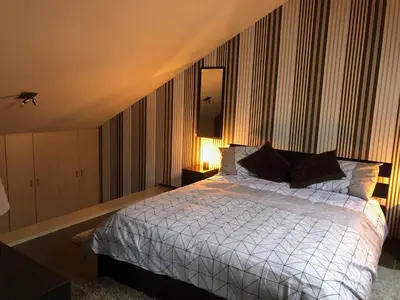 a bedroom with a bed with a white comforter at Gastenverblijf 't Princenhuis in Vechmaal