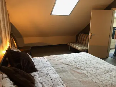 a bedroom with a bed and a window and a couch at Gastenverblijf 't Princenhuis in Vechmaal