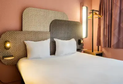 a bedroom with a large bed with two pillows at B&B HOTEL Liège Rocourt in Liège