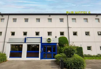 a white building with a sign on top of it at B&B HOTEL Liège Rocourt in Liège