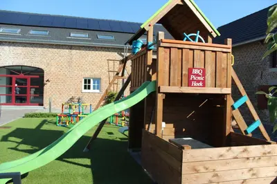 a wooden playground with a slide and a play slope at B&B Hoeve De Brieser in Heers