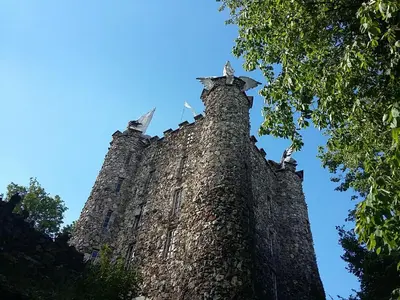 a tall stone building with two pigeons on top of it at VillaEnzo - ELEGANT HERENHUIS - 14P - 6SLPK - SAUNA - INFRAR CABINE - OFYR BBQ - 15MIN Maastricht in Zussen