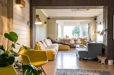 a living room with yellow couches and chairs at ZussEnzo - STOER FAMILIEHUIS - 18P - 5SLPK - GROTE TUIN - SAUNA - OFYR BBQ - HOMECINEMA - 15MIN MAASTRICHT in Zussen