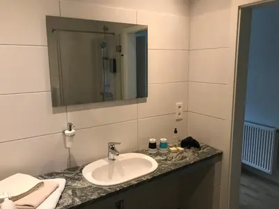 a bathroom with a sink and a mirror at Hotel-Restaurant Zum Onkel Jonathan in Raeren