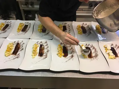 a person is preparing a plate of desserts at Hotel-Restaurant Zum Onkel Jonathan in Raeren