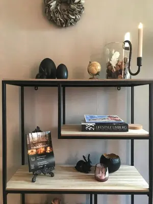 a shelf with a book and other items on it at Le petit béguinage in Tongeren