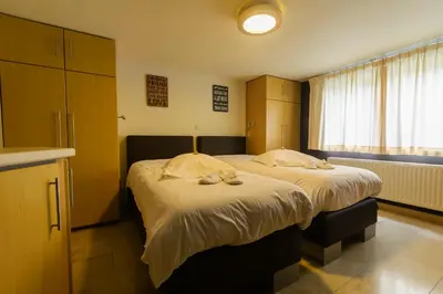 a bedroom with a large bed with towels on it at Hotel Pracha in Borgloon