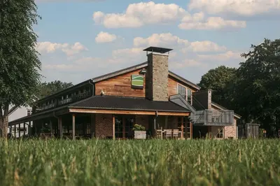 a house sitting in a field of tall grass at Kamphuis Heideven in Peer