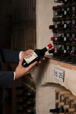 a person holding a bottle of wine on a wall at Kasteel van Ordingen in Sint-Truiden