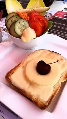 a piece of bread with a cherry on it and a bowl of vegetables at Vakantiepark Wilhelm Tell Superieur Chalet in Oudsbergen