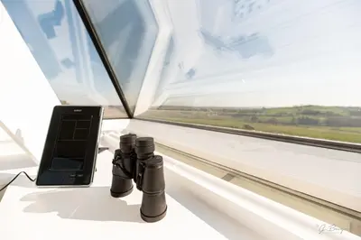 a pair of binoculars and a cell phone next to a window at Logement insolite La tour de Larbuisson in Herve
