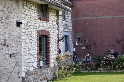 a brick building with a window and flowers on the side at Vakantiewoning Veurservallei in Voeren