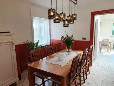 a dining room with a wooden table and chairs at Haspengouws Hoeveke in Borgloon