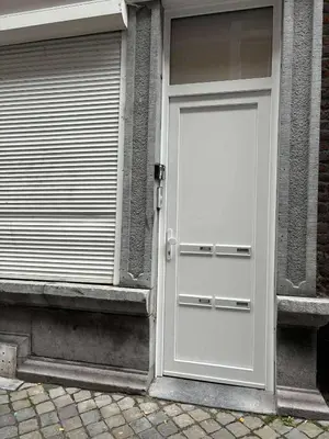 a white door on the side of a building at In The Air cosy room (Cœur Historique de Liège) in Liège