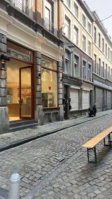 a bench on a street in front of a building at In The Air cosy room (Cœur Historique de Liège) in Liège