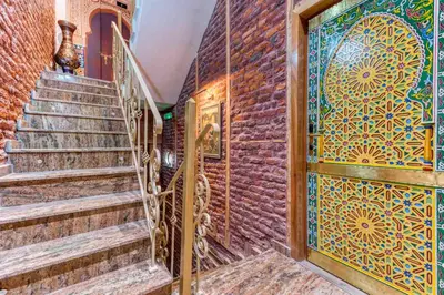 a staircase with a door and a brick wall at Ryad Mogador Liège in Liège