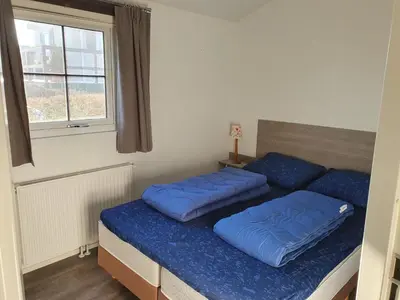 two beds in a room with blue pillows on them at Chalet 11 - Bergzicht Teuven in Teuven