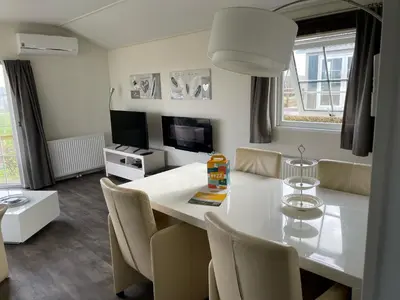 a living room with a white table and chairs at Chalet 11 - Bergzicht Teuven in Teuven