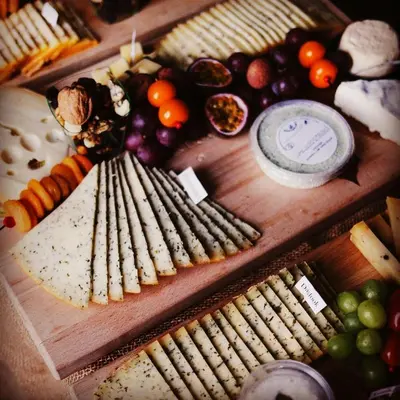 a display of different types of cheese and vegetables at B&B Villa Mimosa in Pelt
