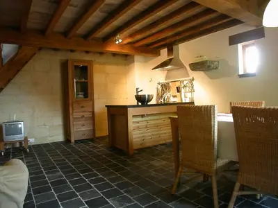 a kitchen with a table and chairs and a tv at De Zwarte Stok in Riemst