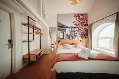 a bedroom with a large bed and a window at Burgemeesterhuys in Beringen