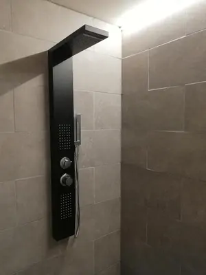 a shower with a black shower head in a bathroom at The Place in Lommel