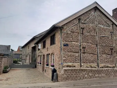 a man standing in front of a brick building at Het Stalhuys in Riemst