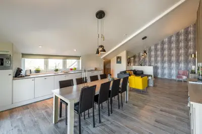 a kitchen and living room with a table and chairs at Bed en Vrijheid in Peer