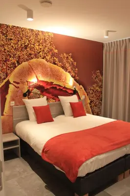 a bedroom with a large bed with red pillows at Vakantiewoning Atuatuca in Tongeren