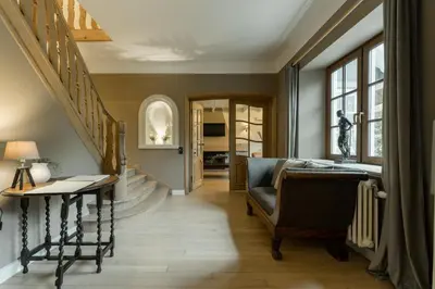 a living room with a staircase and a chair at Vakantiewoning De zandberg in Pelt