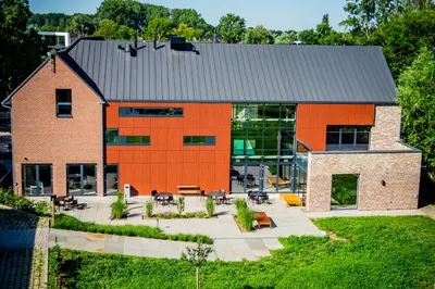 an orange building with tables and chairs in front of it at Hof van Stayen in Sint-Truiden