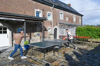 two men playing ping pong on a ping pong table at Landhaus Lontzen in Lontzen