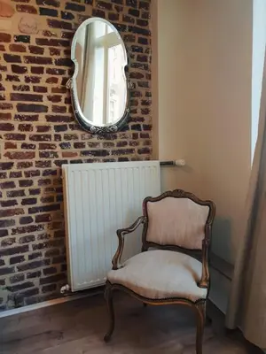 a chair sitting in a room with a mirror at Logies Mario in Tongeren
