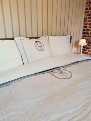 a large bed with white sheets and pillows at Logies Mario in Tongeren