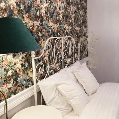 a bedroom with a bed with a floral wallpaper at VIP 67 in Eupen