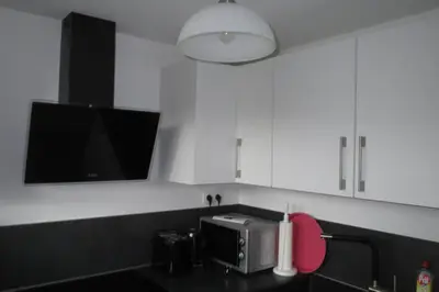 a kitchen with white cabinets and a microwave at Chalet M in Eupen
