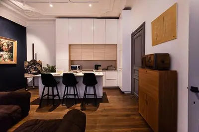 a living room with a kitchen with a counter and chairs at GITADIN - Deluxe Suite Rousseau - Historical center in Liège