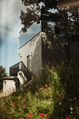 a building with a balcony and flowers in front of it at Kindadom - Maison pour vacances insolites et inoubliables en Belgique in Montzen