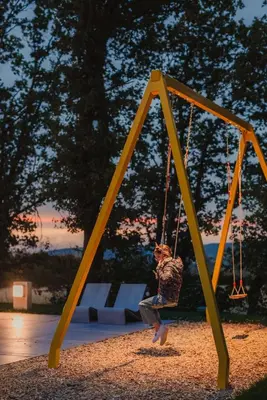 a child on a swing in a playground at Kindadom - Maison pour vacances insolites et inoubliables en Belgique in Montzen